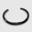 Close up DVNCI black twisted cuff bangle worn model wrist detail shot luxury