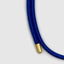 Close up DVNCI 18k gold tip on 2.7mm blue woven silk cord magnetic bracelet
