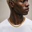 Close up DVNCI milgrain Cuban link chain necklace worn on model neck gold jewelry