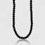 Macro detail of gold rope-textured clasp on onyx bead necklace
