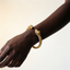 DVNCI 18k yellow gold twin skull woven cuff bracelet angled detail studio shot